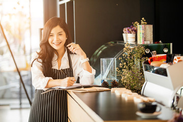Portrait of Young asian beautiful woman barista in her shop. Cafe restaurant service, 