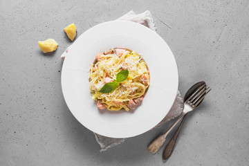 Pasta with trout and cream in white plate on light background. Delicious Mediterranean lunch.