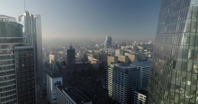 Drone footage of backwards movement in between glass office buildings in Warsaw city center.