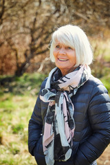 Beautiful senior lady in scarf and jacket, smiling