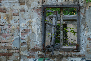 Old house in a village with a broken wooden window.