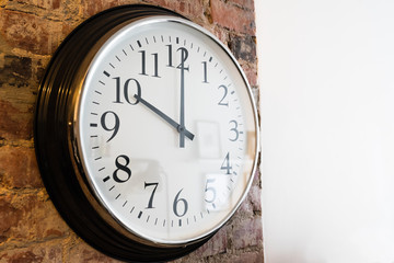 Classic Wall clock on brick wall, white wall on side