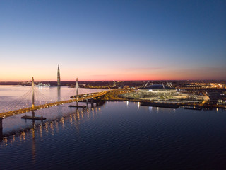 Obraz premium Saint-Petersburg, Russia. Aerial views to Gulf Finland. Skyscraper Lakhta center Gazprom headquarters. Stadium Zenith Arena at night. Illuminated by multi-colored lights the stadium at night.