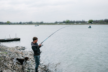 Fisherman fishes spinning from the shore in spring