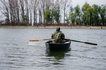 A man is rowing in a wooden boat