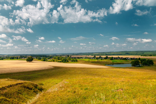 Panoramic high angle view of the plain, the village and the lake from hill top.