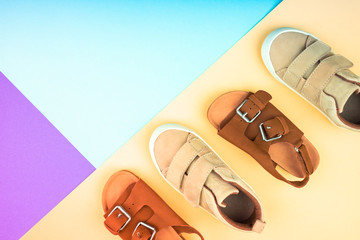 Sneakers and sandals on a trendy color background, top view, summer shoes.