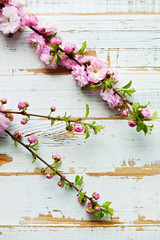 Bunch of spring flowering branches with a lot of white-pink blossoms on wooden background. Rustic composition w/ spring flowers on vintage textured wood table. Close up, copy space, top view.