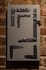 Old door holes and handles - Wooden entrance on brick walls - Handles made of metal