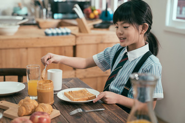 Peanut butter sandwich toast bread on wooden table kitchen at home morning. smiling happy little...