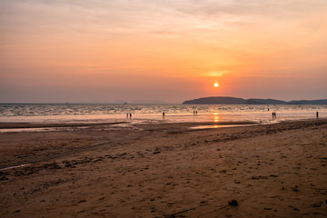 Panoramic photo of beautiful sunset over the sea, sun goes behind the mountain. Golden colors