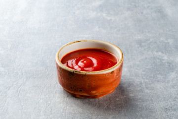 Tomato and chili sauce, ketchup on a gray stone