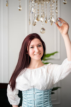 young caucasian woman in a sky blue corset and white shirt ready for historical ball dance