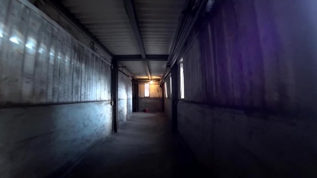 Worker walk through a dark corridor at a metallurgical plant. POV, action camera shot.