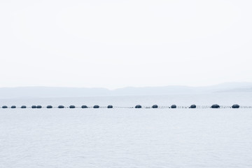 Fish farm salmon nets cages floats in sea water coast environment organic farming at Loch Melfort...