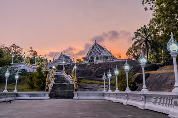 Wat Kaew Korawaram or The white temple in Krabi with grand staircase lined by naga sculptures. Sunset orange sky