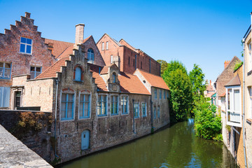 Fototapeta na wymiar houses with orange roof tiles along canal in historic town Bruges, Brugge, Belgium. Speelmansrei