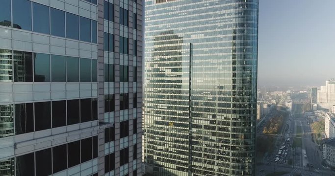 Drone footage of backwards movement next to glass office buildings in Warsaw city center.