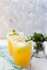 Refreshing homemade lemonade with ice, lime and mint.  on a white wooden table.