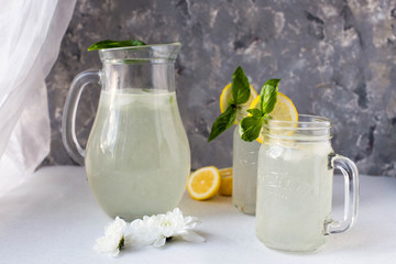 Organic refreshing cocktail with lemon and ice. Summer. Lemonade. Flowers. Glass. Mint.
