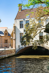 Fototapeta na wymiar tunnel, water and white building across canal in Brugge, Bruges, Belgium