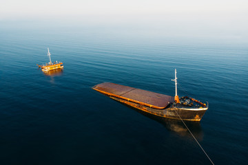 Sunken cargo ship near Crimean seaside, aerial view from drone. Shipwreck vessel with nose of ship above sea water