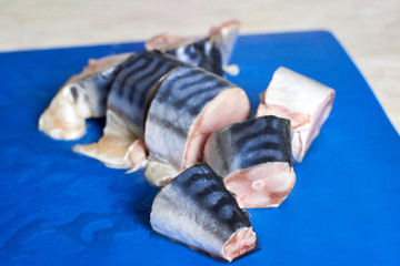 Fresh sliced mackerel lies on a plastic kitchen board