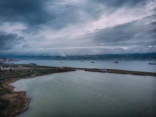 clouds hanging over the mountains, rainy weather in the city of Novorossiysk. View of the Cemes Bay, the port, and the "Small land"