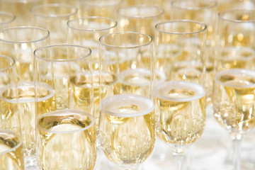 A row of glasses filled with champagne are lined up ready to be served. Coffee break prepare for serve guests attending seminar.break time in meeting room