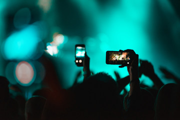 Fototapeta na wymiar People holding their smart phones or mobile phones and photographing concert