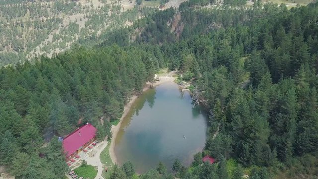 aerial dolly forwards drone shot over Karagol Lake next to green idyllic forest, in slow motion, in Karsiyaka of Izmir, Turkey