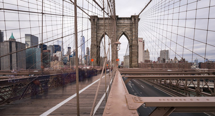 A long exposure of the Brooklyn Bridge at daytime with Manhattan in the background.