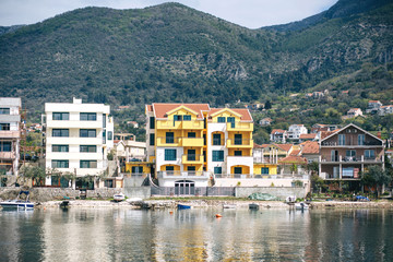 Fototapeta na wymiar Beautiful view on the background of the mountains on residential buildings or the architecture of the coastal city of Tivat in Montenegro.