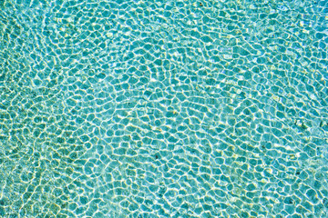 Crystal clear Soca river water texture effect green and blue colored water pattern made by natural sun light on a sunny day, Slovenia