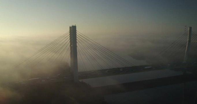 Drone footage of Siekierkowski bridge in Warsaw, taken during a foggy day.