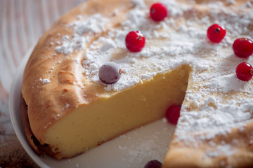 Children breakfast with Cheesecake with cranberries and sugar on wooden table