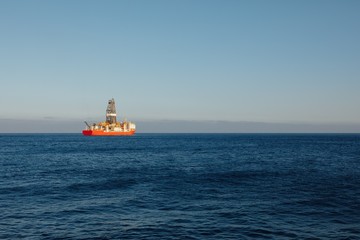 offshore oil and gas drillship, blue ocean background