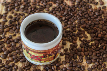 cup of coffee with beans on white background