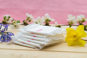 Six sanitary napkins on a wooden table.