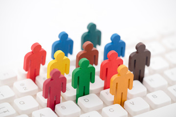 Colorful painted group of people figures on computer keyboard