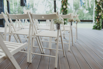 Wedding ceremony with white chairs.