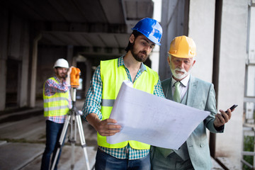 Confident team of architects and engineers working together on construction site