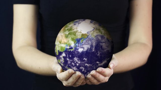 Young woman holds realistic Earth in her handsю Element of this video furnished by NASA