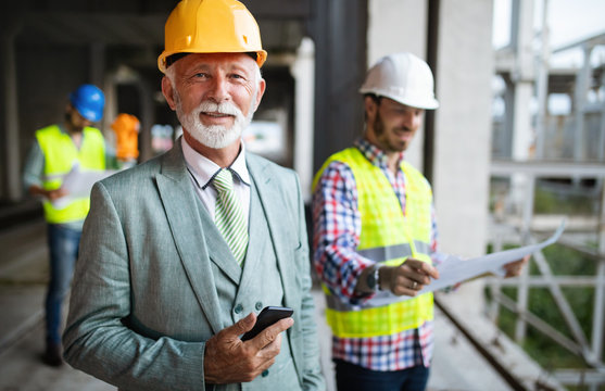Confident team of architects and engineers working together on construction site