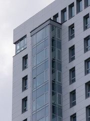 A modern building in the city. Glass windows on the balconies