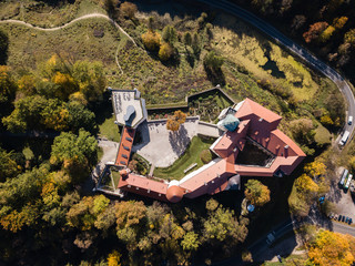 Historic castle Pieskowa Skala near Krakow in Poland. Aerial view in fall at sunrise in morning fog.