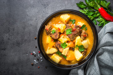 Beef stew with vegetables - carrot, ppototo and pumpkin on black