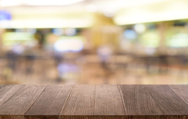 Fototapeta premium Empty dark wooden table in front of abstract blurred bokeh background of restaurant . can be used for display or montage your products.Mock up for space.