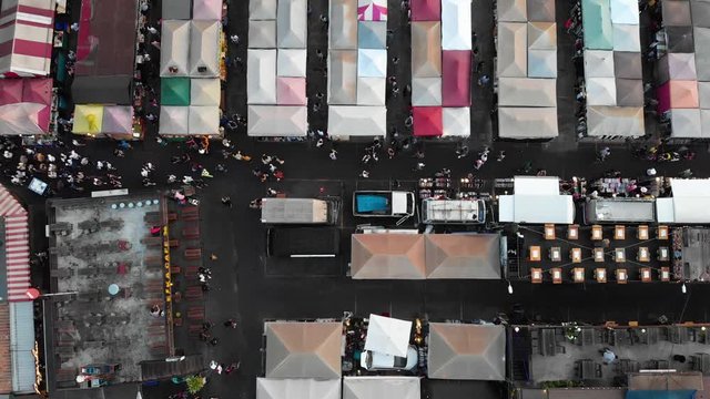 Locked-off top down aerial shot Ratchada Rot Fai Train Night Market Bangkok. People shopping groceries and market stalls.