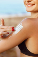 Sun Cream. Skin and Body Care. Woman in Bikini  Applying Sunscreen Solar on Tanned  Shoulder. Sun Protection lotion sunburn. Girl Holding Moisturizing Sunblock.